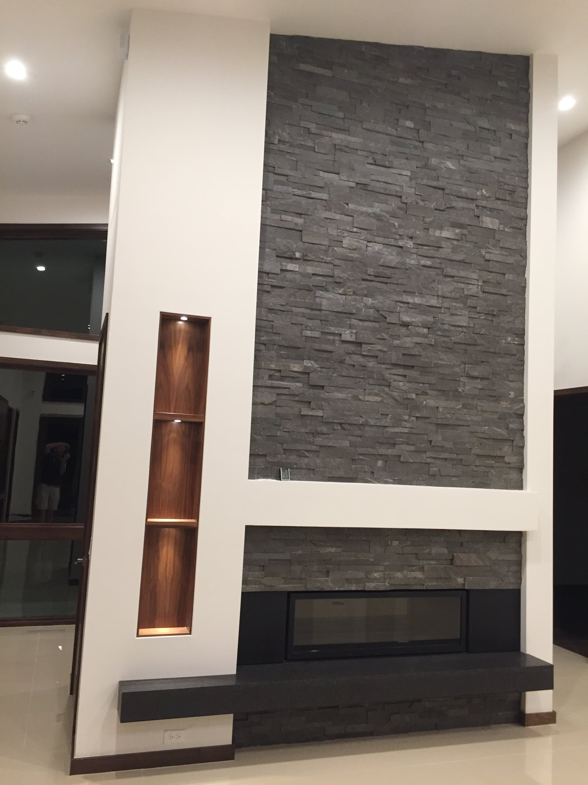 Norstone Charcoal Stacked Stone Rock Panels on a Floor to Ceiling Fireplace in a mid centry Modern styled living room